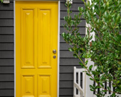 A bright yellow front entrance door in a renovated old Queensland home